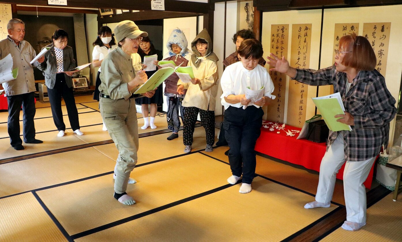 福山空襲を題材にした朗読劇の初公演に向け、藤井登美子さんらが演技指導を受ける様子。中国新聞デジタル掲載の報道写真。
