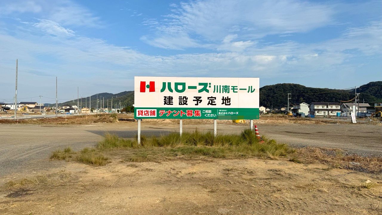 2025年11月8日時点のハローズ川南モール建設予定地付近。更地と工事看板、周辺の生活商業施設が写る（号外NET福山市の現地レポート掲載写真）