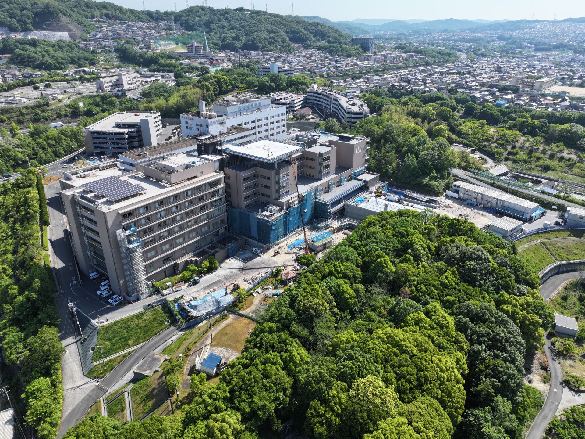 福山市民病院新本館増改築工事の進捗。外周整備や救命救急センター配置に関わる建設現場の様子。